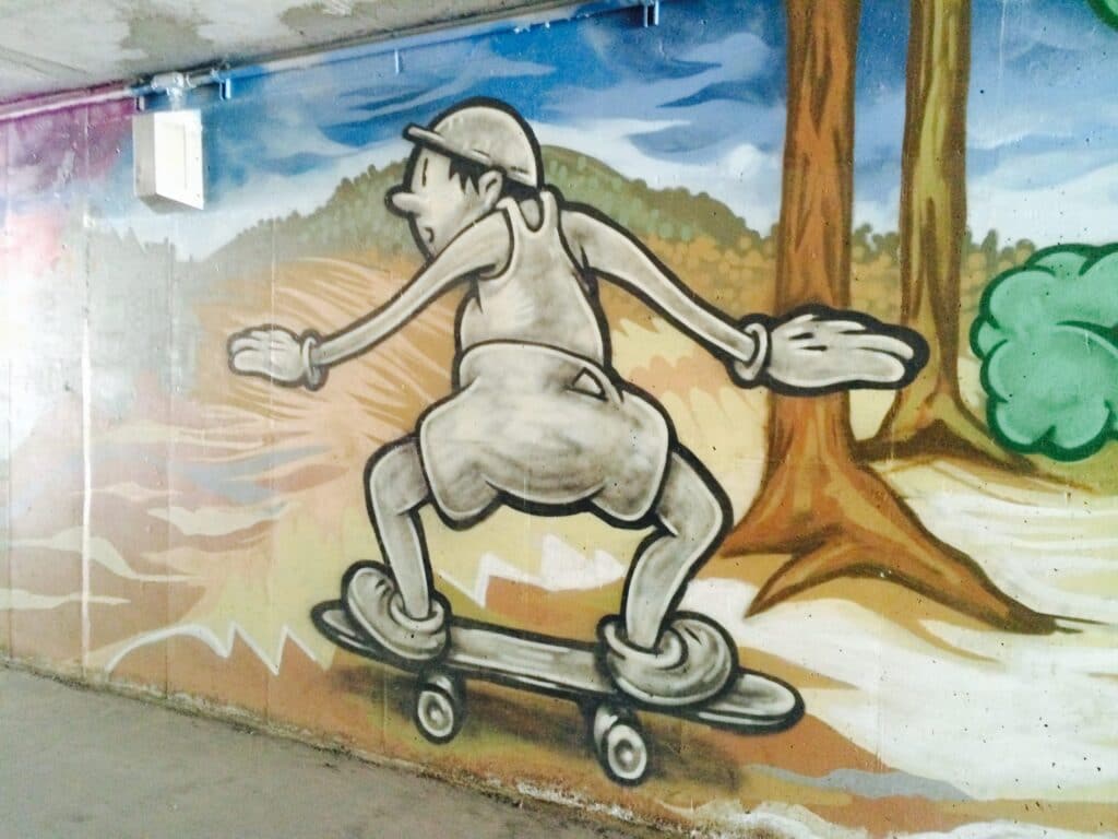Street Art painting of a nostalgic skate boarder in artist Trent Call's signature cartoon style.