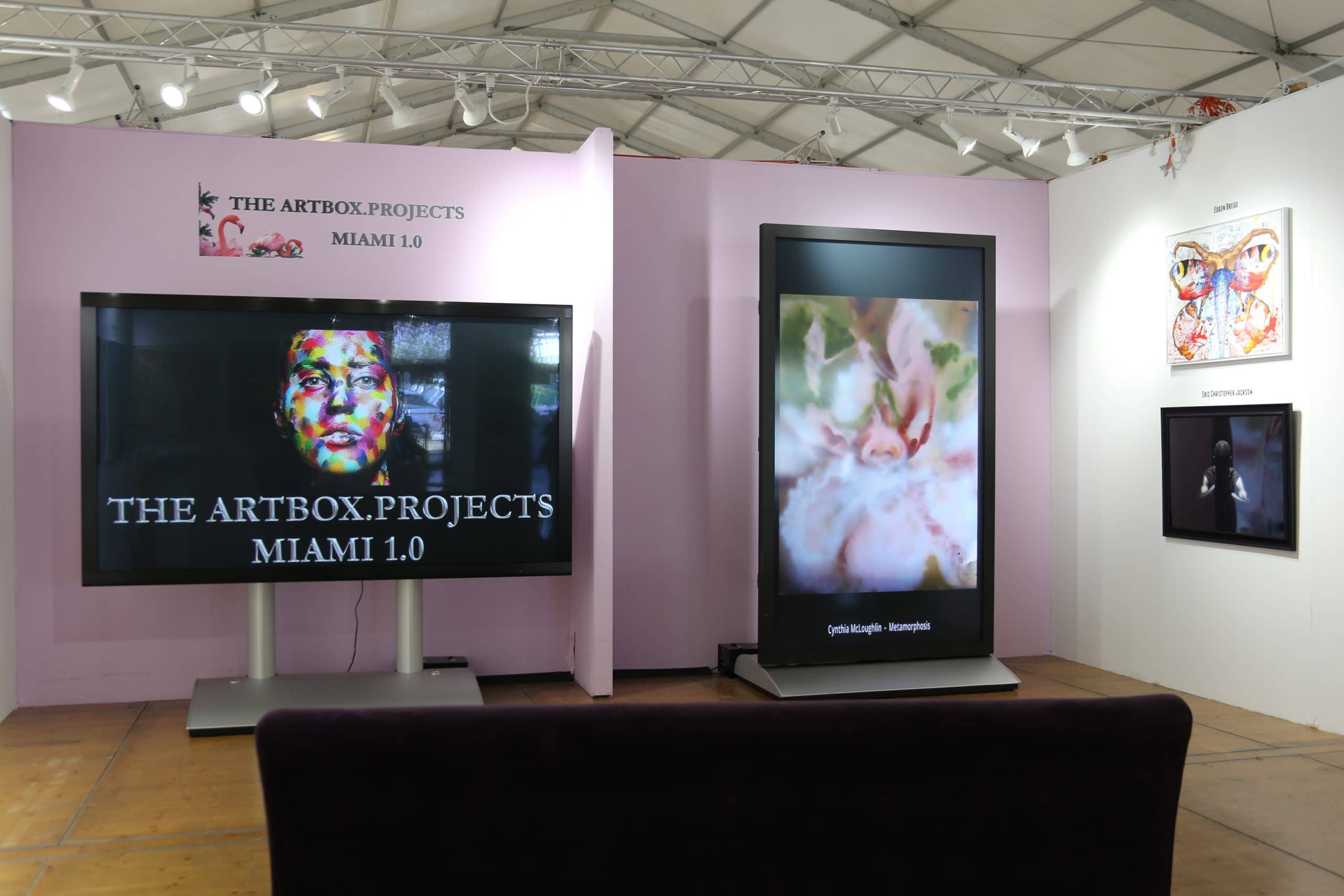 A large orchid/iris hybrid in soft pinks and mossy greens, spray painted by artist Cynthia McLoughlin, displayed in the Artbox Project's booth at the Miami Spectrum show, 2016.