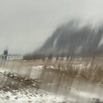 The camera jumped as we hit a bump and the blurred the vision of the mountain, trees and snowy foreground as we drive by 