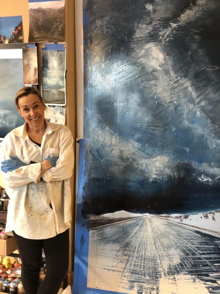 Cynthia McLoughlin in her studio in front of her painting, Celestial Rhapsody.