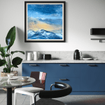 Evening Glow by Cynthia McLoughlin: contemporary landscape oil painting of snow-capped Wasatch mountains at sunset, featuring luminous blue and gold sky, displayed in a modern kitchen with blue cabinets, Park City, Utah.