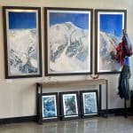 Triptych Landscape oil painting of the iconic Pipeline chute in Utah's Wasatch Mountains, featuring a steep, dramatic ski line beneath an expansive, glowing sky rendered in expressive, layerd tones of deep blue. in the Summit Gallery in Park City, Utah.