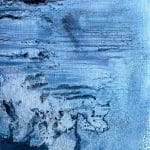 Pale blue abstract painting with scraped horizontal layers, exposed textures and darker forms that suggest eroded rock, water and a shifting shoreline.