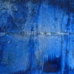 Horizontal abstract painting in layered cobalt and deep blue with a narrow pale horizon-like line suggesting distant water, light and atmospheric space.